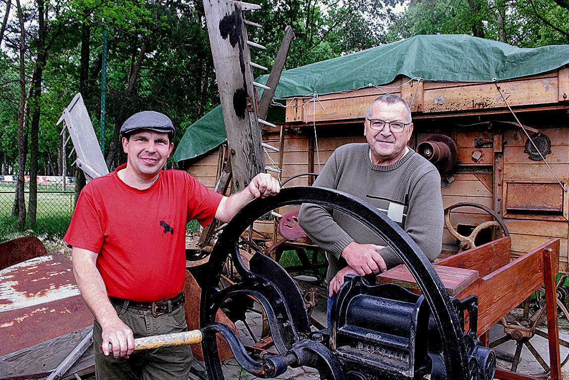 Marek Kozłowski (po lewej) i Sylwester Przydrożny przy jednej z maszyn przed Izbą. To ponadstuletnia żniwiarka pochodząca z Wysp Brytyjskich