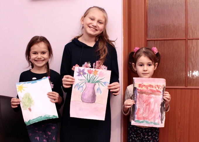 Dziewczynki mieszkające u Agnieszki z Lubochni ze swoimu rysunkami. Od lewej: Emilia, Julia i Melania, córka Ivanki